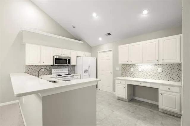a kitchen with appliances a sink and cabinets