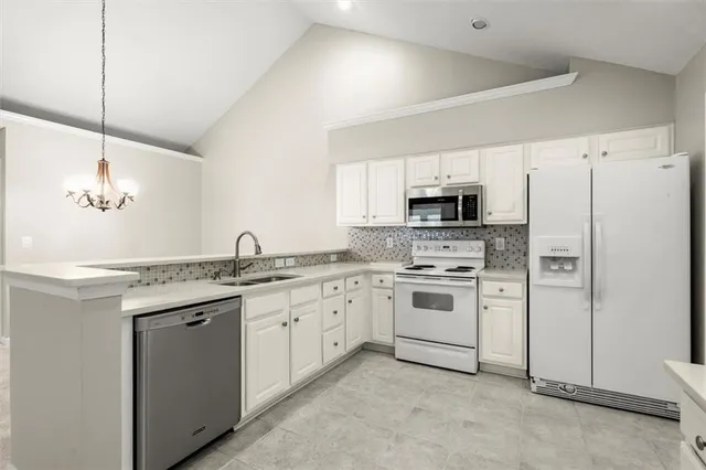 a kitchen with granite countertop white cabinets and stainless steel appliances