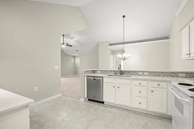 a kitchen with granite countertop white cabinets and white appliances