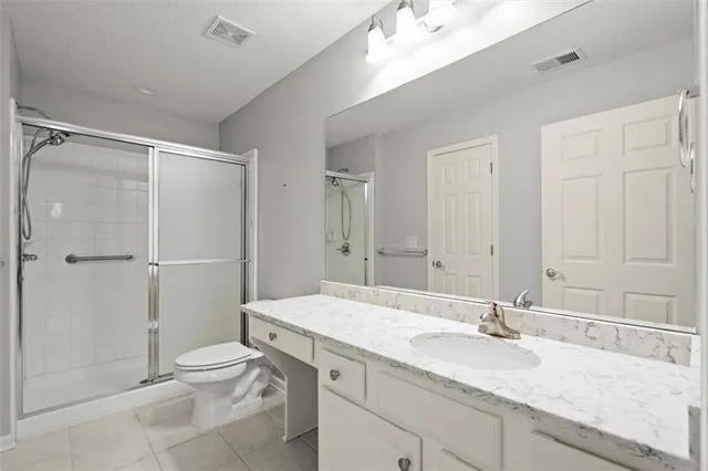 a bathroom with a granite countertop sink toilet and shower