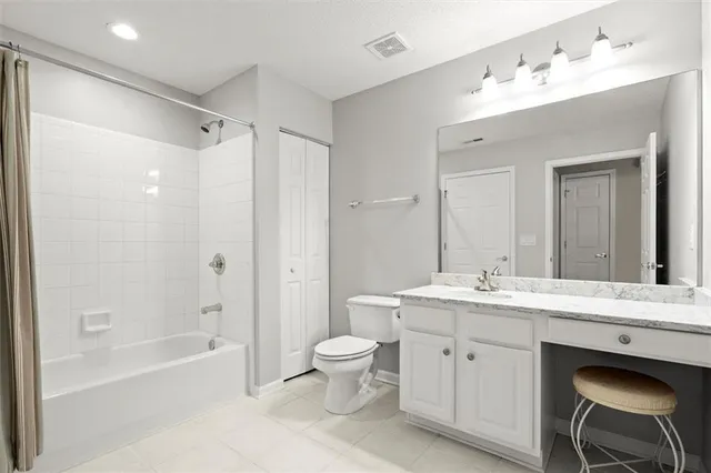 a spacious bathroom with a bathtub shower sink mirror and toilet