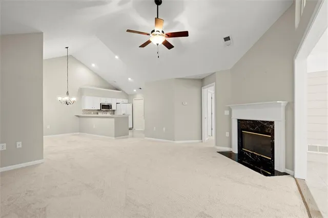 a view of kitchen and empty room with fireplace