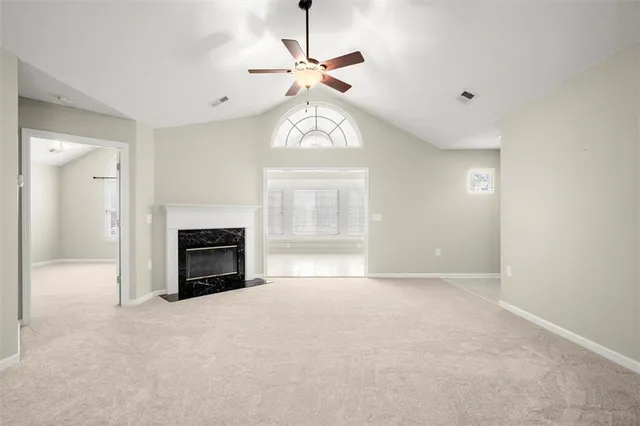 a view of empty room with fireplace and fan