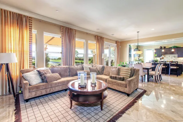 a dining room with furniture a floor to ceiling window and chairs