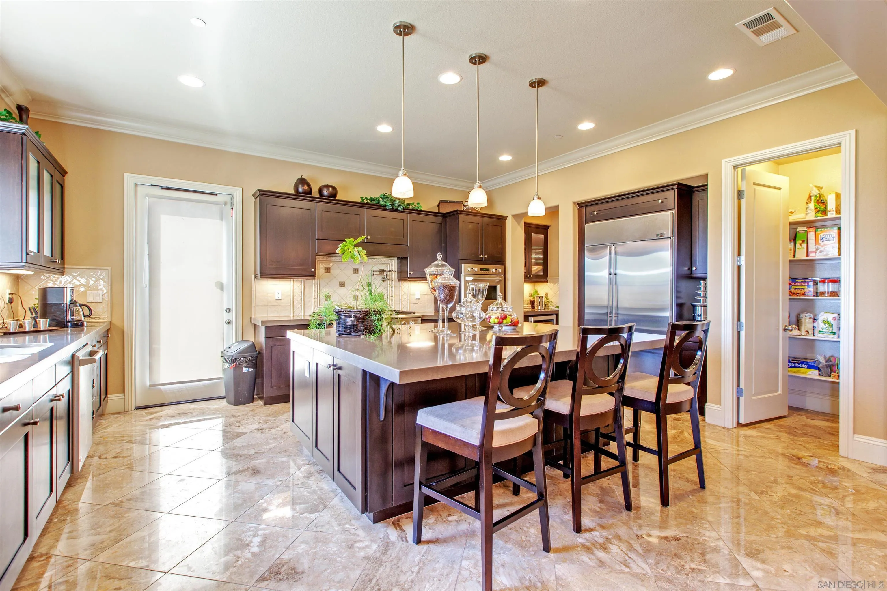 671 Via Maggiore Chula Vista, CA 91914 - Photo 15 of 42 a kitchen with stainless steel appliances kitchen island granite countertop a table chairs and a refrigerator