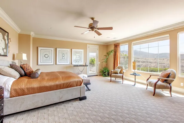 a spacious bedroom with a bed and a cabinets