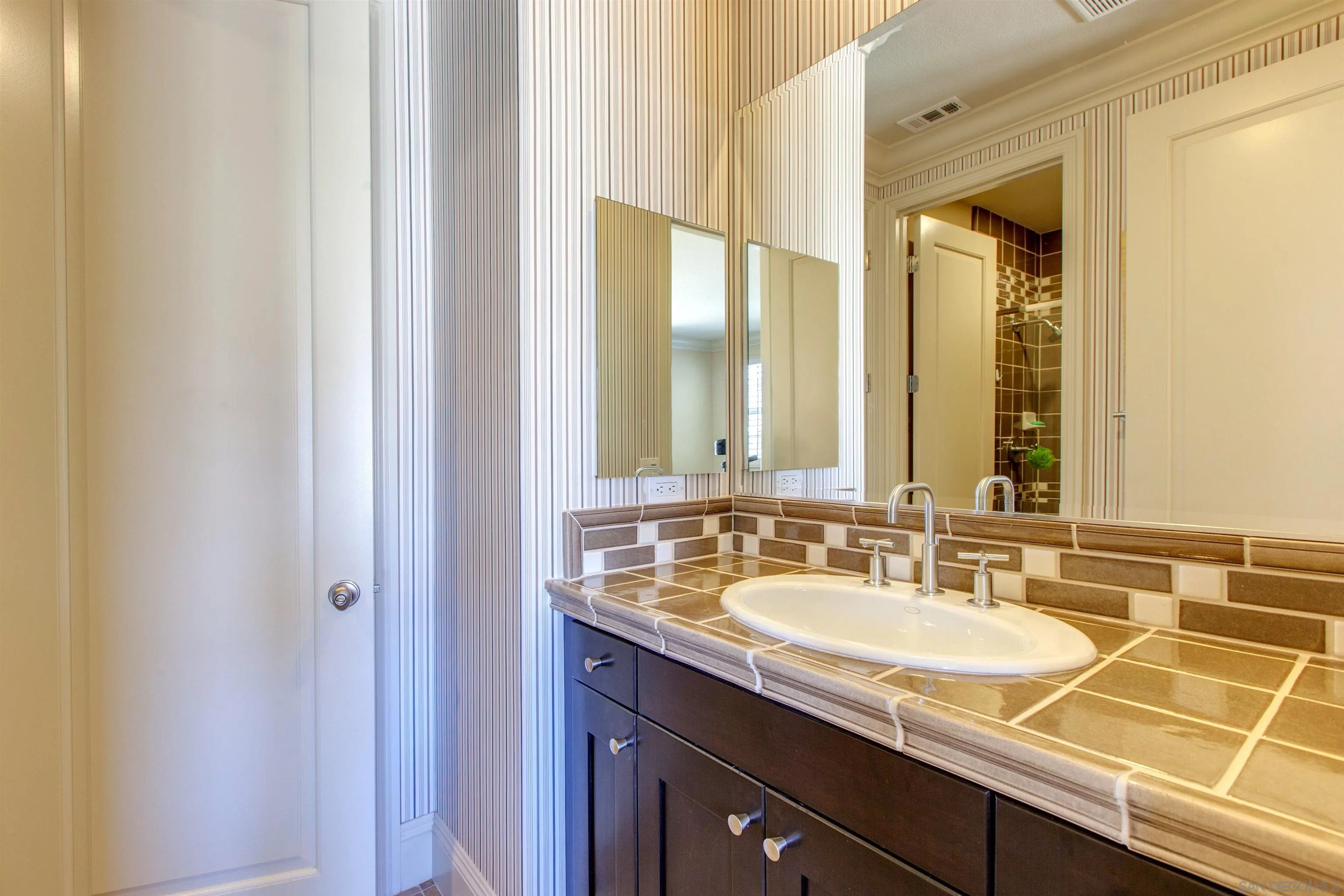 671 Via Maggiore Chula Vista, CA 91914 - Photo 31 of 42 a bathroom with a granite countertop sink and a mirror