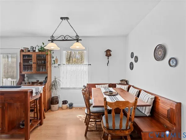 a view of a dining room with furniture a chandelier and wooden floor