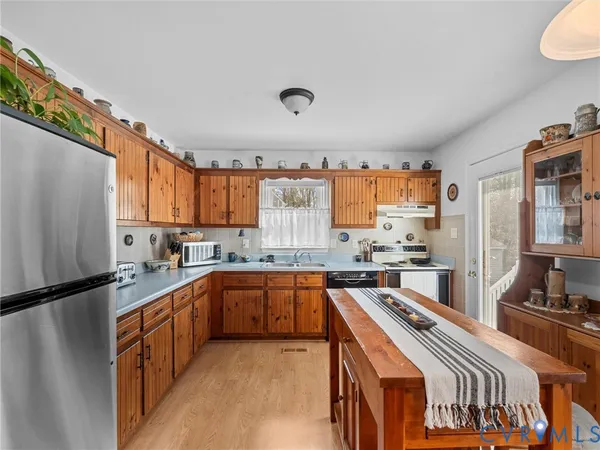 a kitchen with stainless steel appliances a refrigerator sink and cabinets