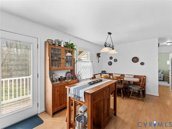 a kitchen with stainless steel appliances granite countertop a refrigerator a sink dishwasher a dining table and chairs with wooden floor