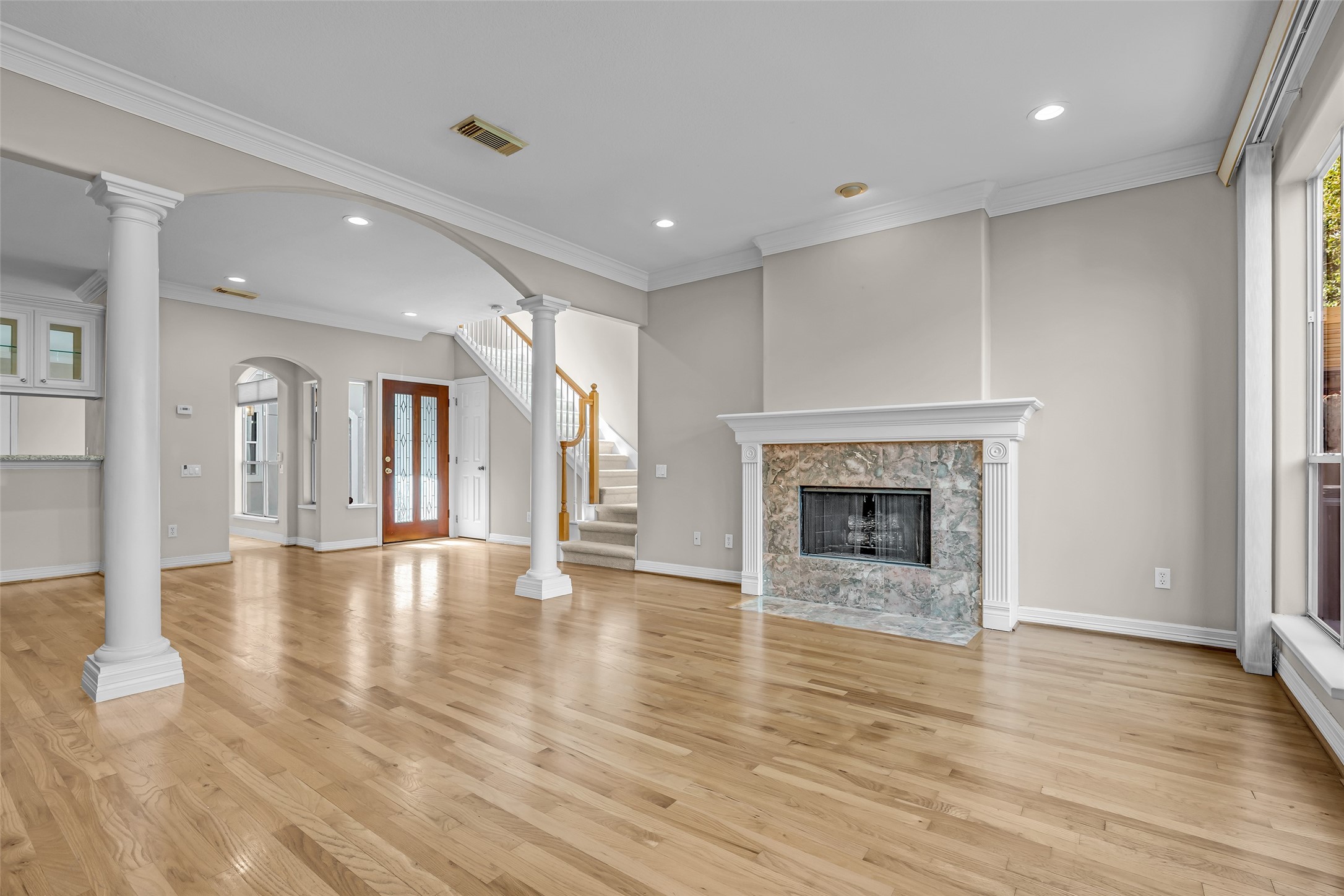 4916 Travis Street Houston, TX 77004 - Photo 8 of 27 a view of an empty room with wooden floor fireplace and a window