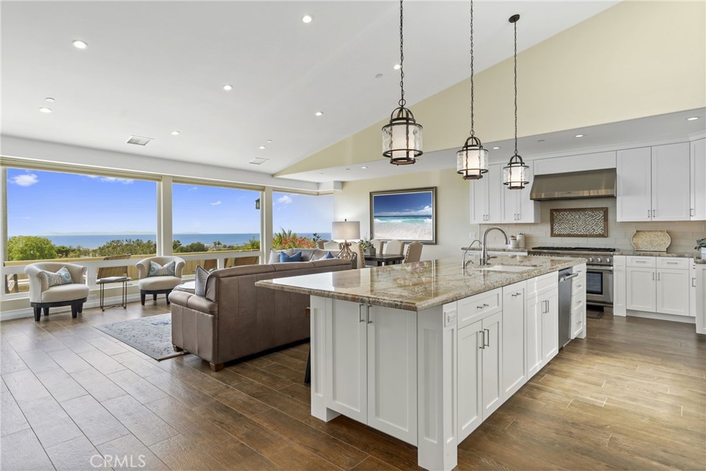 a large kitchen with kitchen island lots of counter space a sink appliances and living room view
