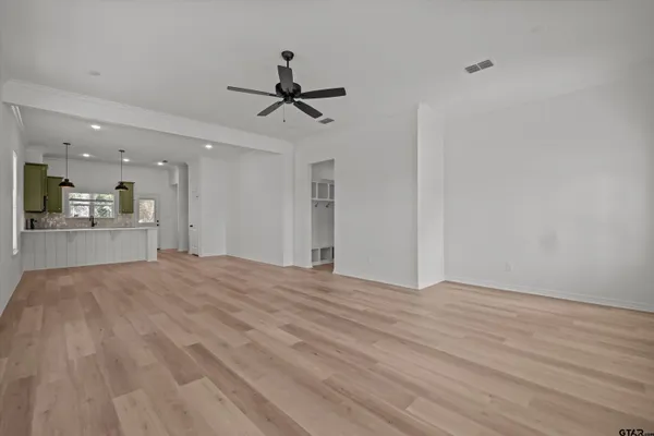 a room with stainless steel appliances kitchen island a dining table chairs and a sink