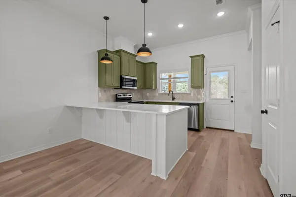 a view of a kitchen with wooden floor and cabinets