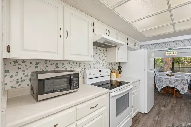 a kitchen with white cabinets and white appliances
