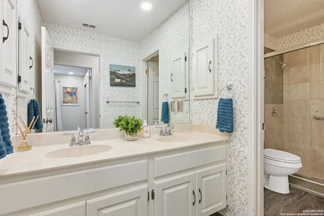 a bathroom with a sink a toilet and shower