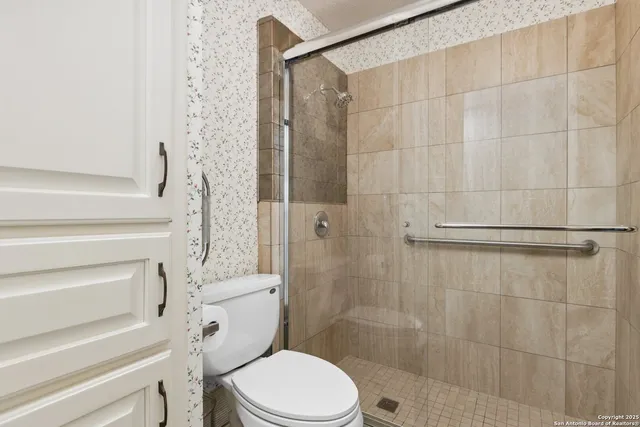 a bathroom with a toilet and a shower