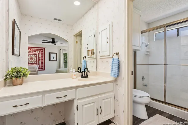 a bathroom with a sink a toilet and shower