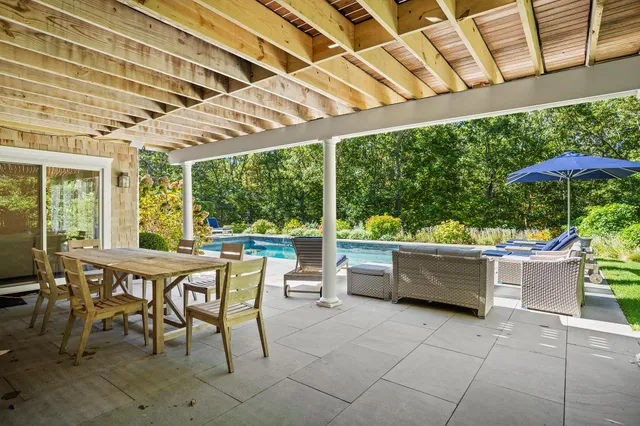 a view of a patio with a dining table and chairs under an umbrella