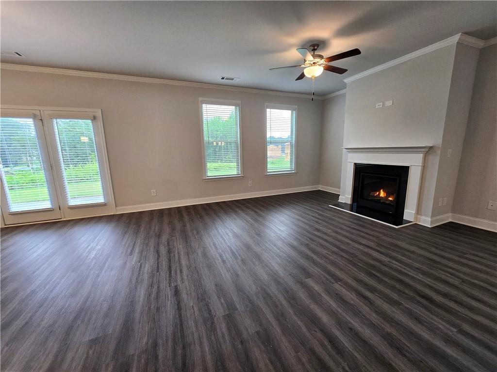 3856 Lockaby Way Lawrenceville, GA 30044 - Photo 12 of 36 an empty room with wooden floor fireplace and windows