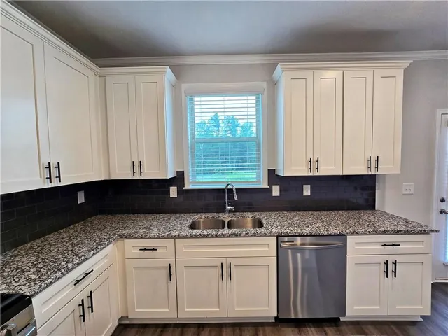 a kitchen with granite countertop a sink and a stove