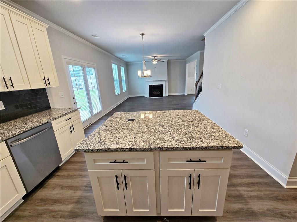 3856 Lockaby Way Lawrenceville, GA 30044 - Photo 22 of 36 a kitchen with stainless steel appliances granite countertop a stove a sink dishwasher and white cabinets with wooden floor
