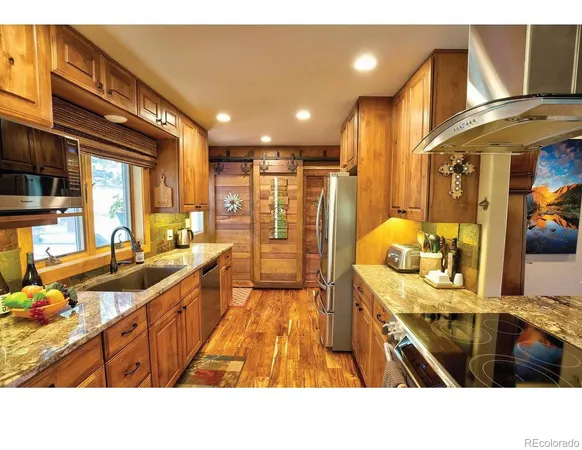 a open kitchen with stainless steel appliances kitchen island granite countertop a sink and cabinets