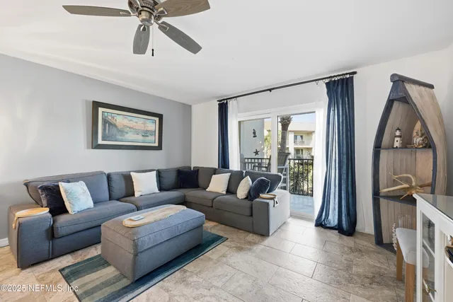a living room with furniture and a view of kitchen