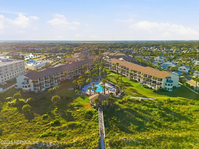 an aerial view of residential houses with outdoor space and swimming pool