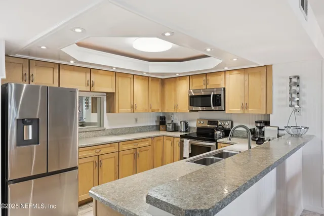a large kitchen with stainless steel appliances granite countertop a stove and cabinets