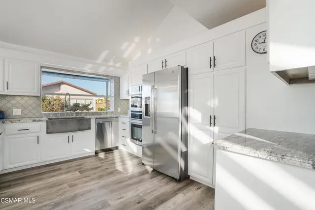 a kitchen with granite countertop a refrigerator and a sink