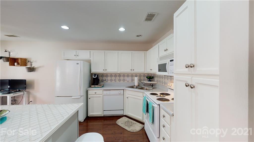 11642 Rabbit Ridge Road Charlotte, NC 28270 - Photo 10 of 45 a kitchen with a sink a stove a refrigerator and white cabinets