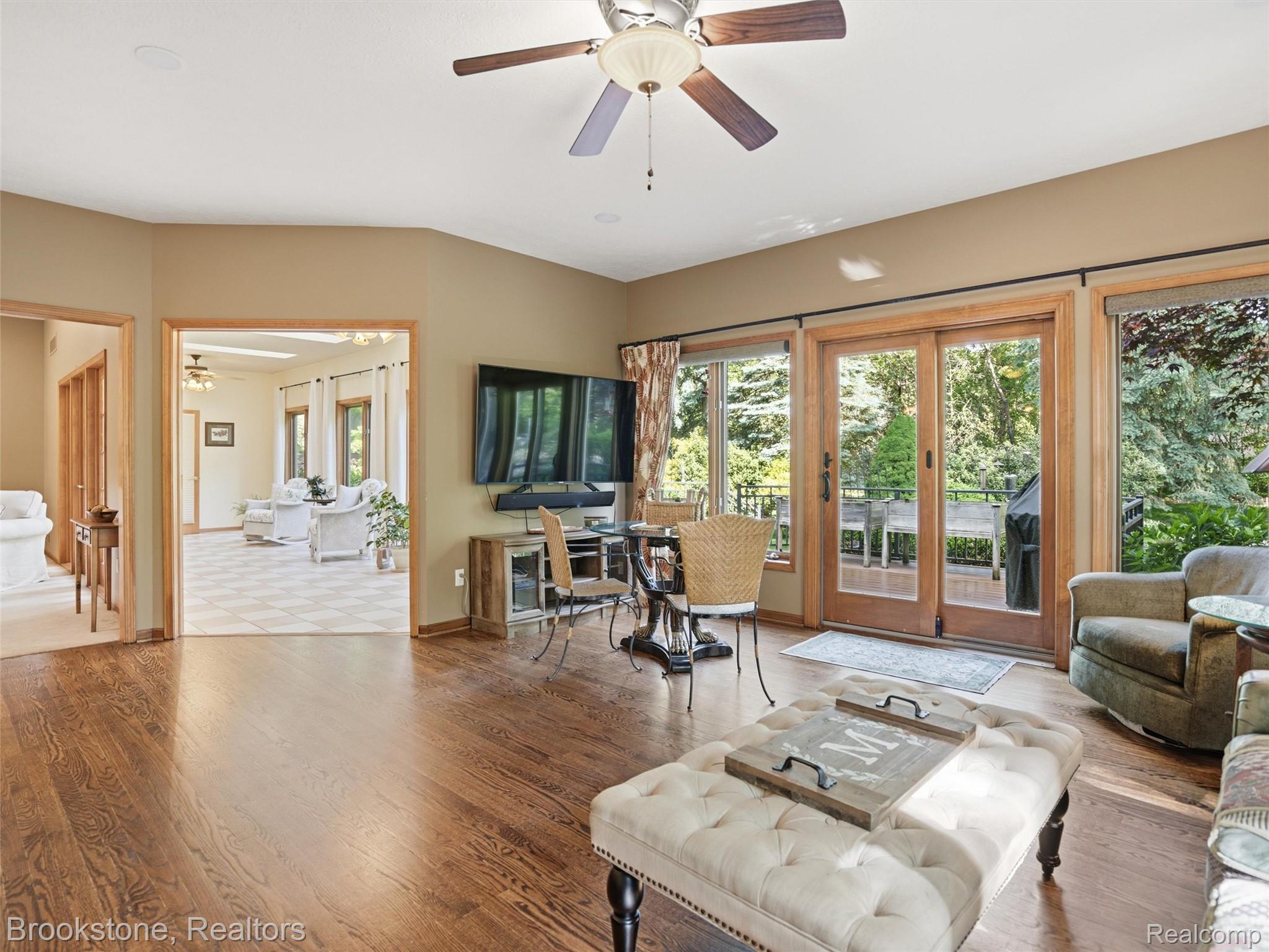 9523 Quail Ridge Run Brighton, MI 48114 - Photo 19 of 50 Hardwood flooring in a living area featuring a ceiling fan, recessed lighting, and sliding glass doors leading to an outdoor deck