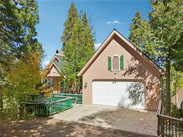 a view of a house with a yard and large tree