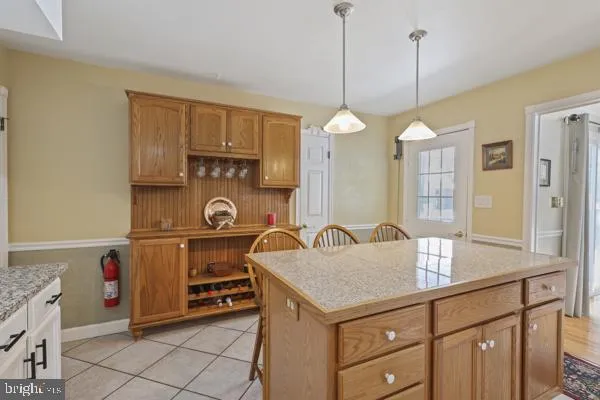 a kitchen with kitchen island granite countertop a sink a stove and a wooden floors