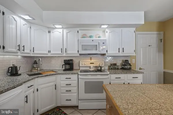 a kitchen with stainless steel appliances granite countertop a sink a stove and cabinets