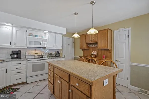 a kitchen with a stove a sink a center island and cabinets