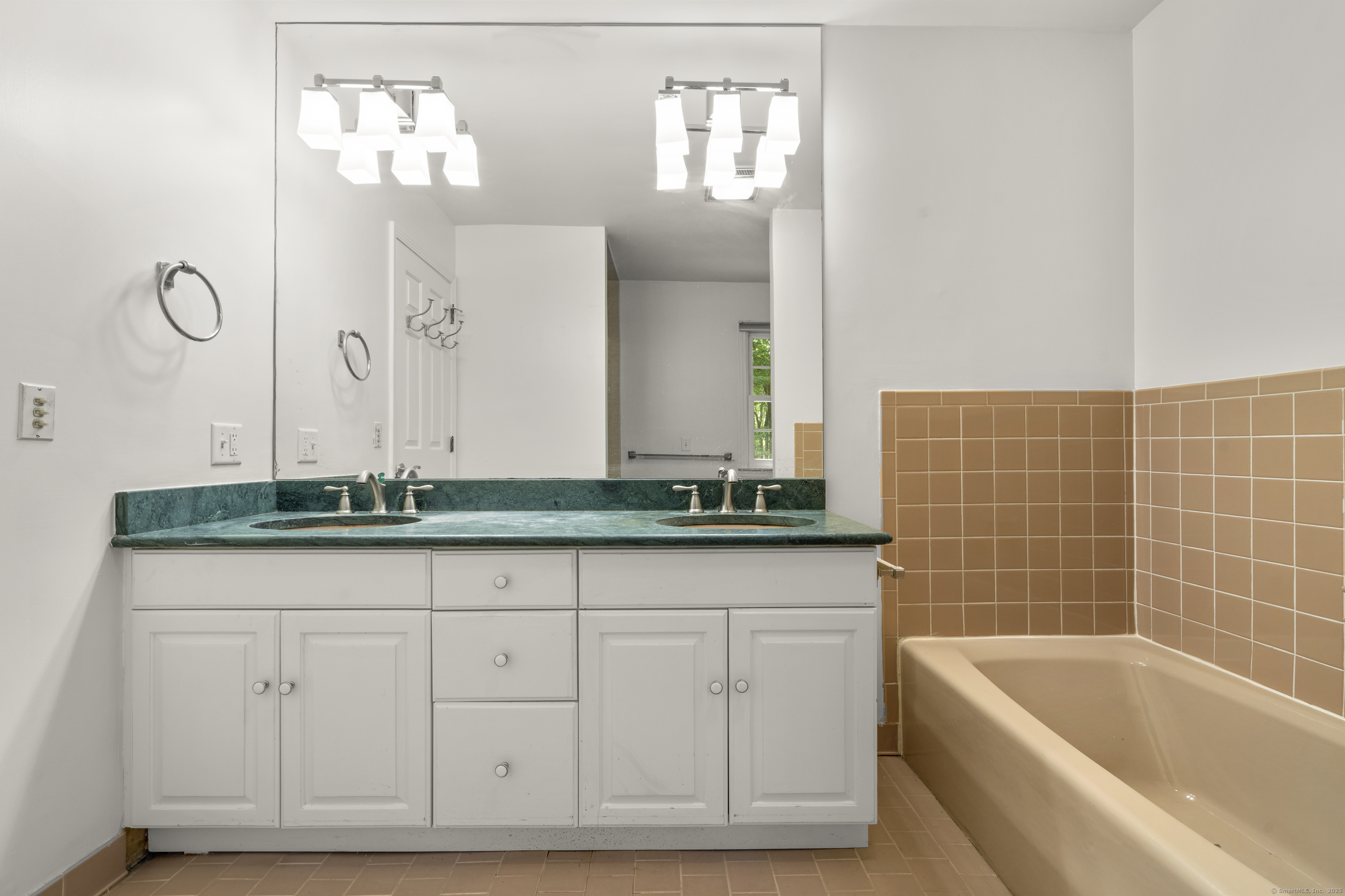 181 Old Boston Road Wilton, CT 06897 - Photo 17 of 30 a bathroom with a granite countertop bathtub a sink and a window