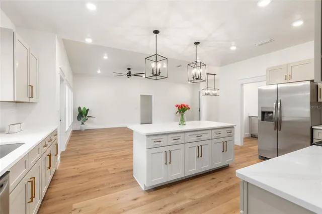 a kitchen with stainless steel appliances granite countertop a sink a refrigerator and a stove