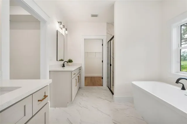 a bathroom with a tub sink and mirror