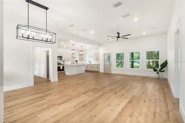 a view of a kitchen with refrigerator and wooden floor