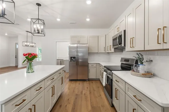 a kitchen with stainless steel appliances granite countertop a sink a stove and refrigerator