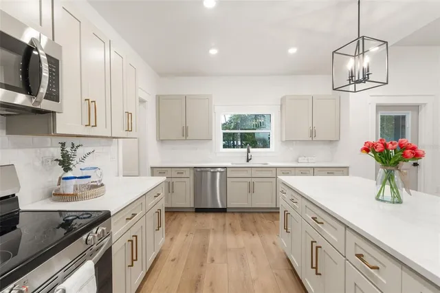 a kitchen with cabinets wooden floor a sink and appliances