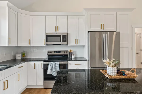 a kitchen with granite countertop a refrigerator stove and microwave