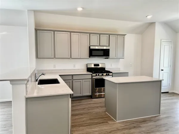 a kitchen with appliances a sink and a microwave