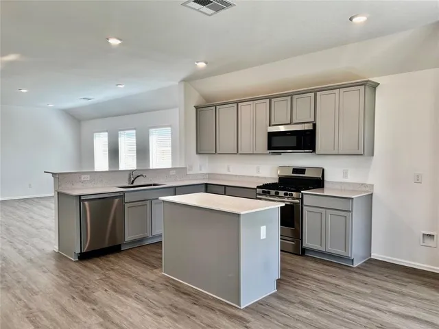 a kitchen with a sink stove and microwave