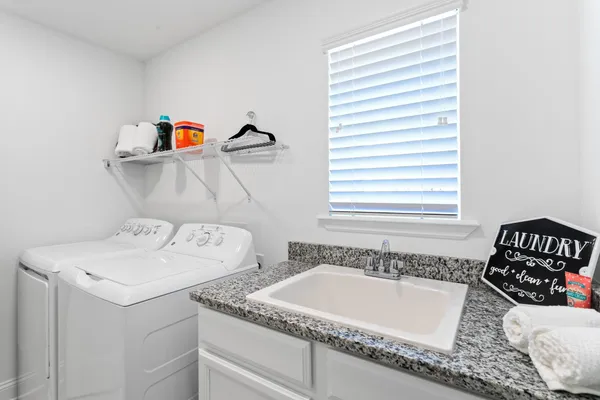 a utility room with faucet and washer