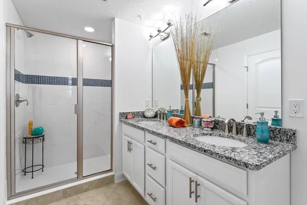 a bathroom with double vanity and a mirror