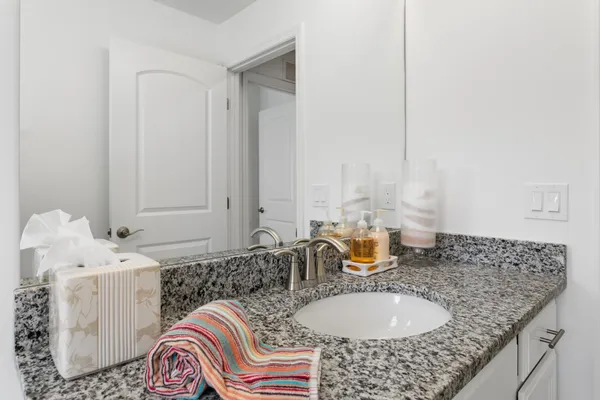 a bathroom with a granite countertop sink and a mirror
