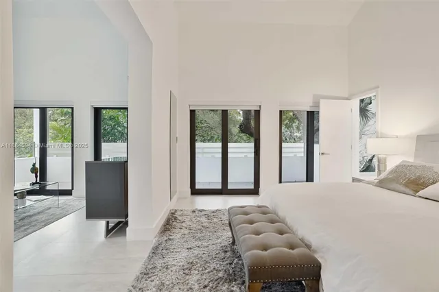 a bedroom with furniture and large windows